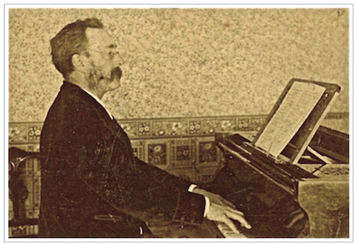 Side view of James Shaw in velvet smoking jacket and handlebar moustache playing on a grand piano in his music roomdrawing room
